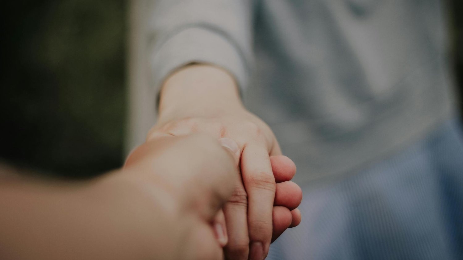 Wyniki badań pokazały ciemną stroną nadopiekuńczości. "Wyręczałam dzieci we wszystkim" Na zdjęciu rodzic podający dziecku rękę.