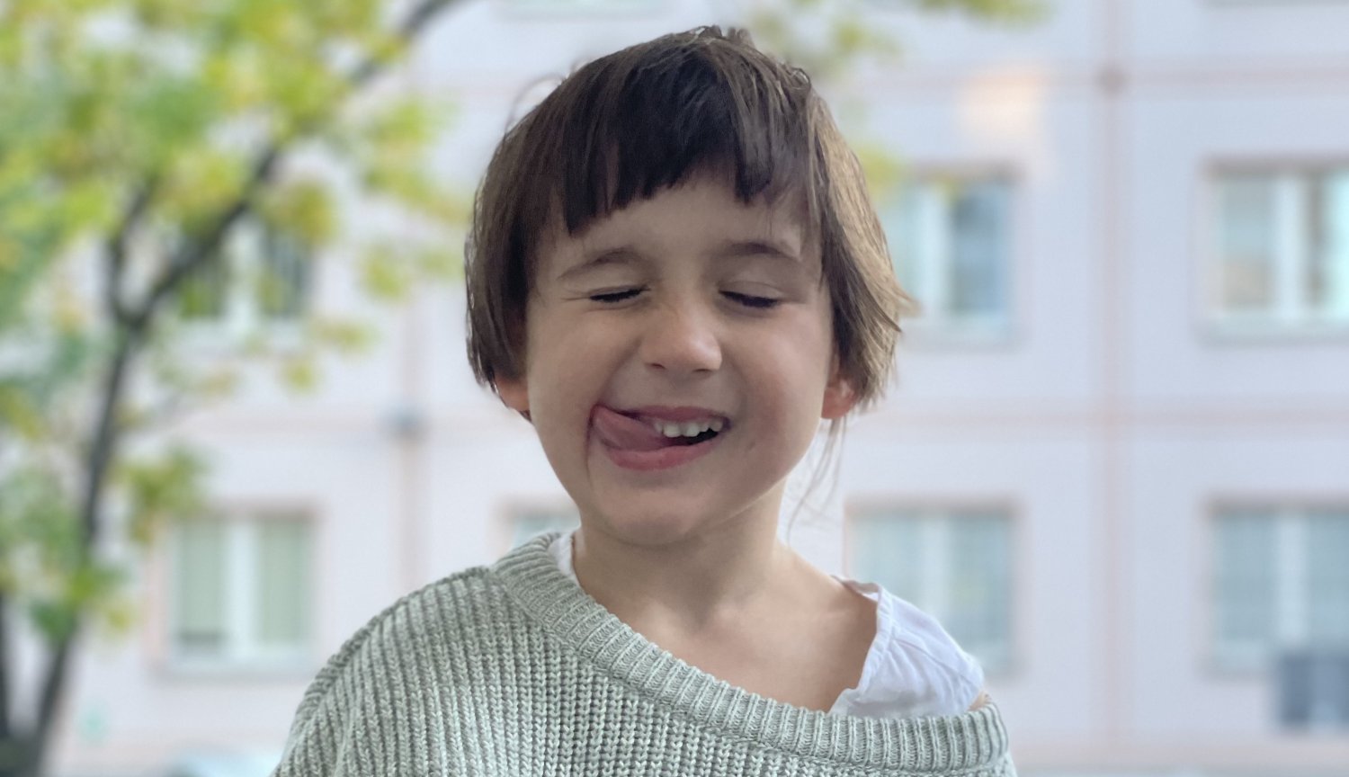 Dziewczynka ma zamknięte oczy, wystawia język.