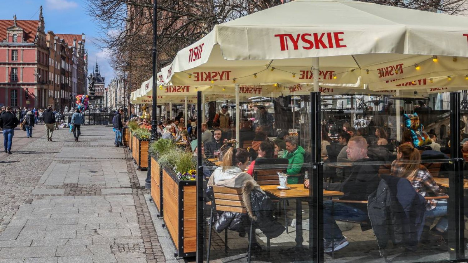 Ogródek restauracyjny, w którym rodzice jedzą obiad.