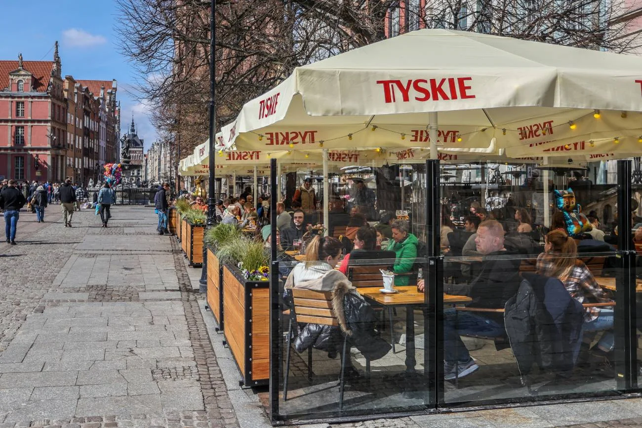 Ogródek restauracyjny, w którym rodzice jedzą obiad.