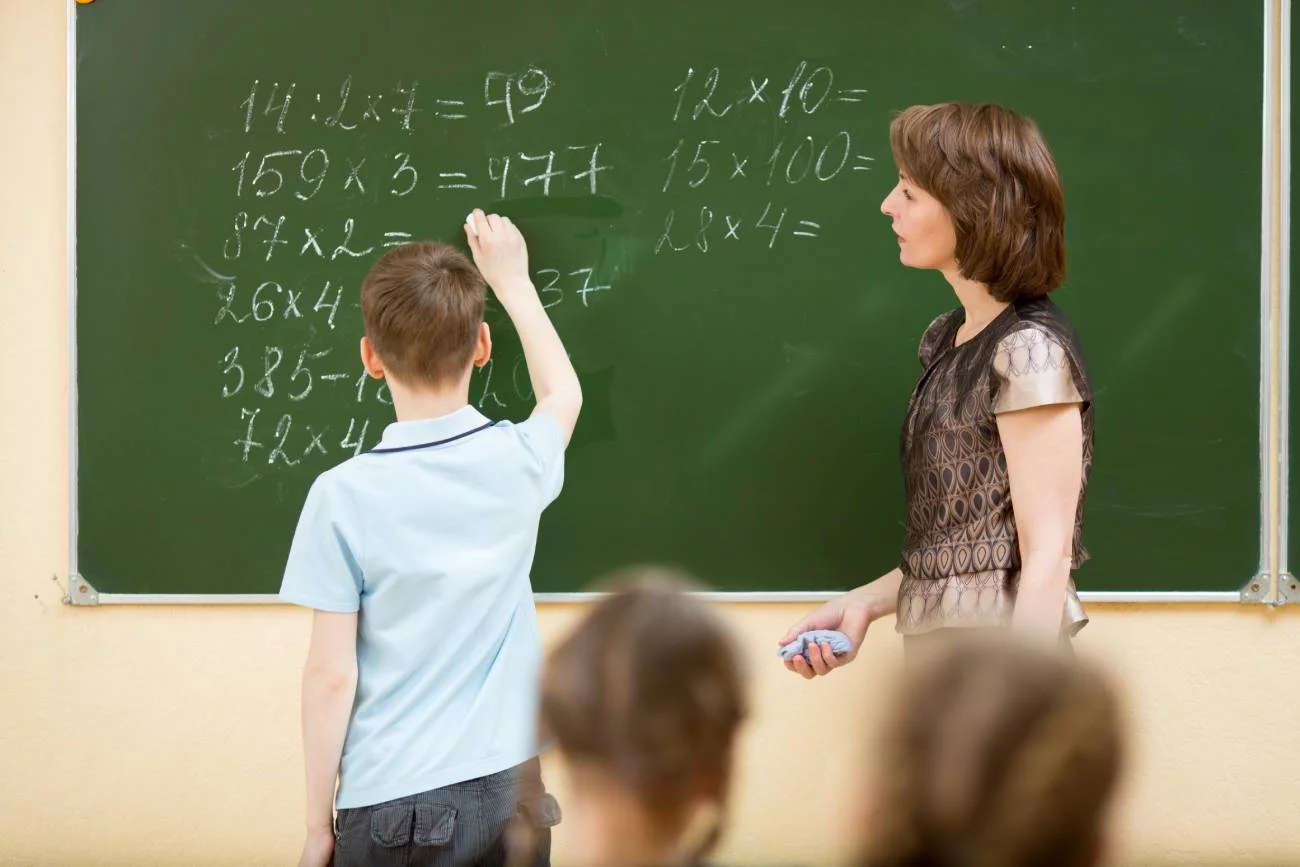 Nauczycielka na lekcji rozwiązuje z uczniem zadania.