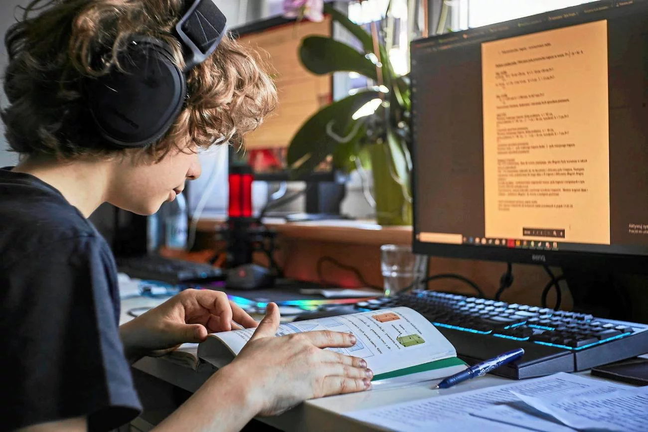 uczeń w domu odrabia lekcje przy komputerze uczeń w domu odrabia lekcje przy komputerze