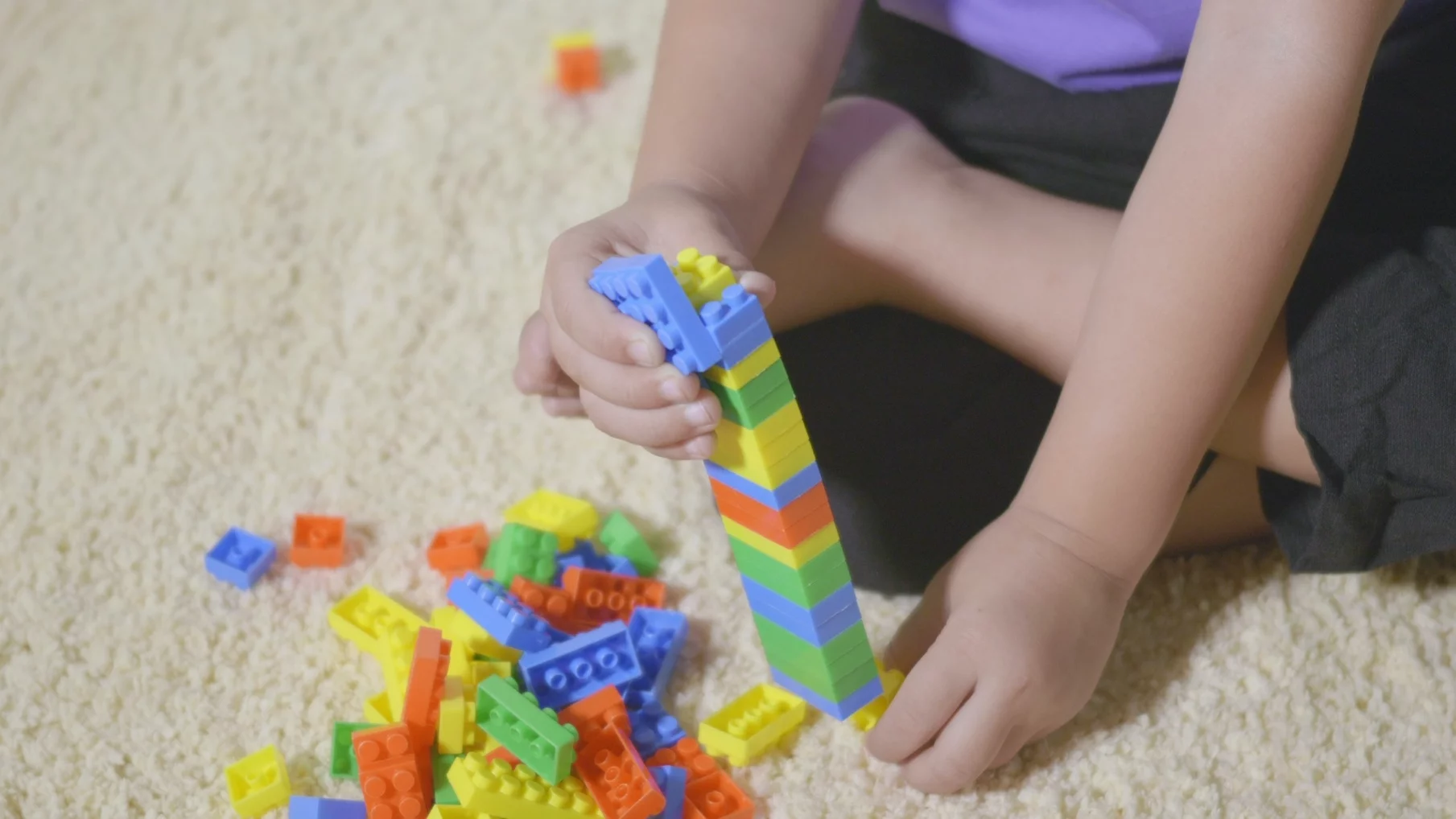 Na zdjęciu dziecko bawi się klockami