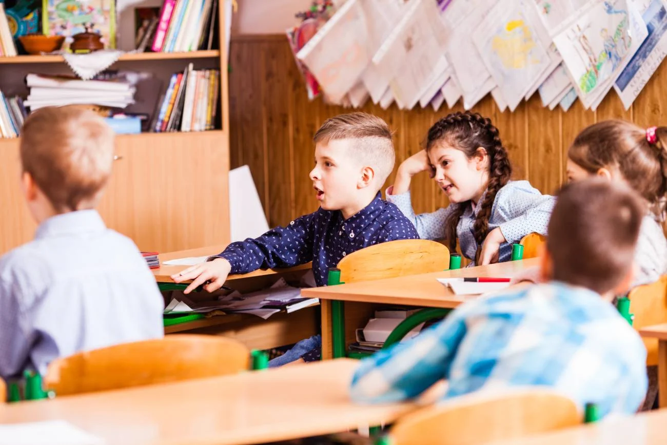 Dzieci w klasie siedzą w ławkach na lekcji. Dzieci w klasie siedzą w ławkach na lekcji.