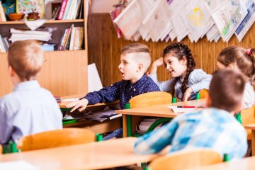 Dzieci w klasie siedzą w ławkach na lekcji. Dzieci w klasie siedzą w ławkach na lekcji.