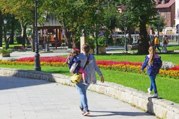 Mama idzie przez miasto z dwójką dzieci. Mama idzie przez miasto z dwójką dzieci.