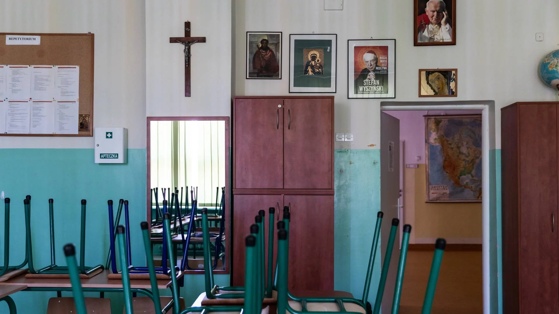 klasa lekcyjna w szkole z krzyżem i obrazami świętych na ścianie klasa lekcyjna w szkole z krzyżem i obrazami świętych na ścianie