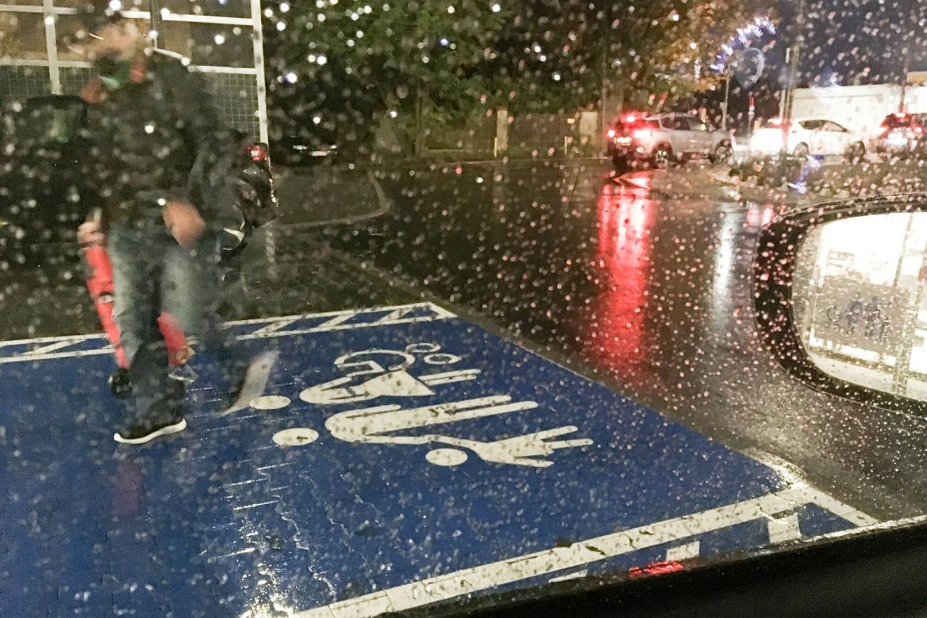 Mężczyzna idzie przez parking po miejscu parkingowym dla rodziny z dzieckiem.