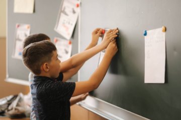 Uczniowie pracują na lekcji przy tablicy.