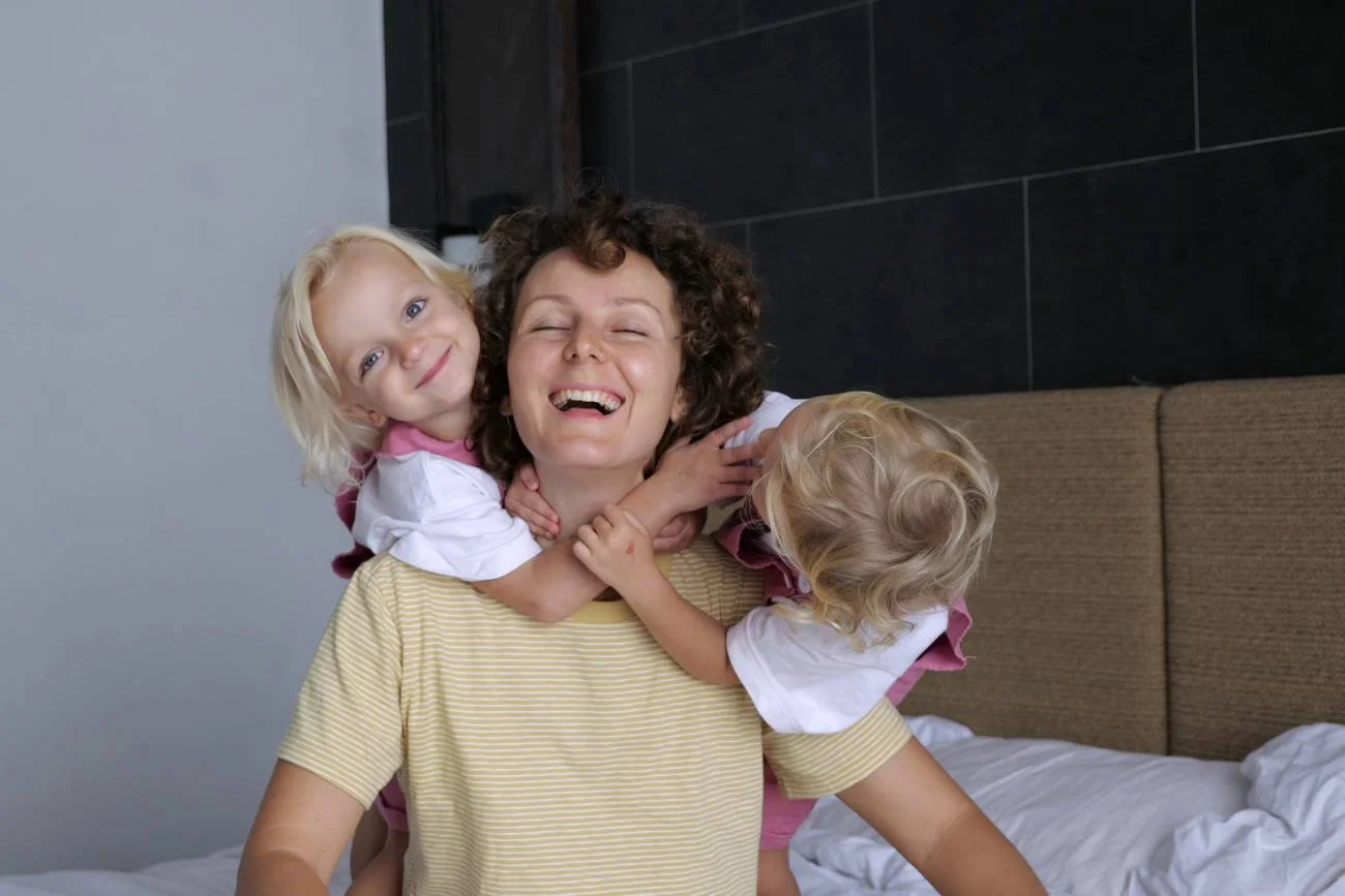 mama bawi się na łóżku z dwójką dzieci mama bawi się na łóżku z dwójką dzieci