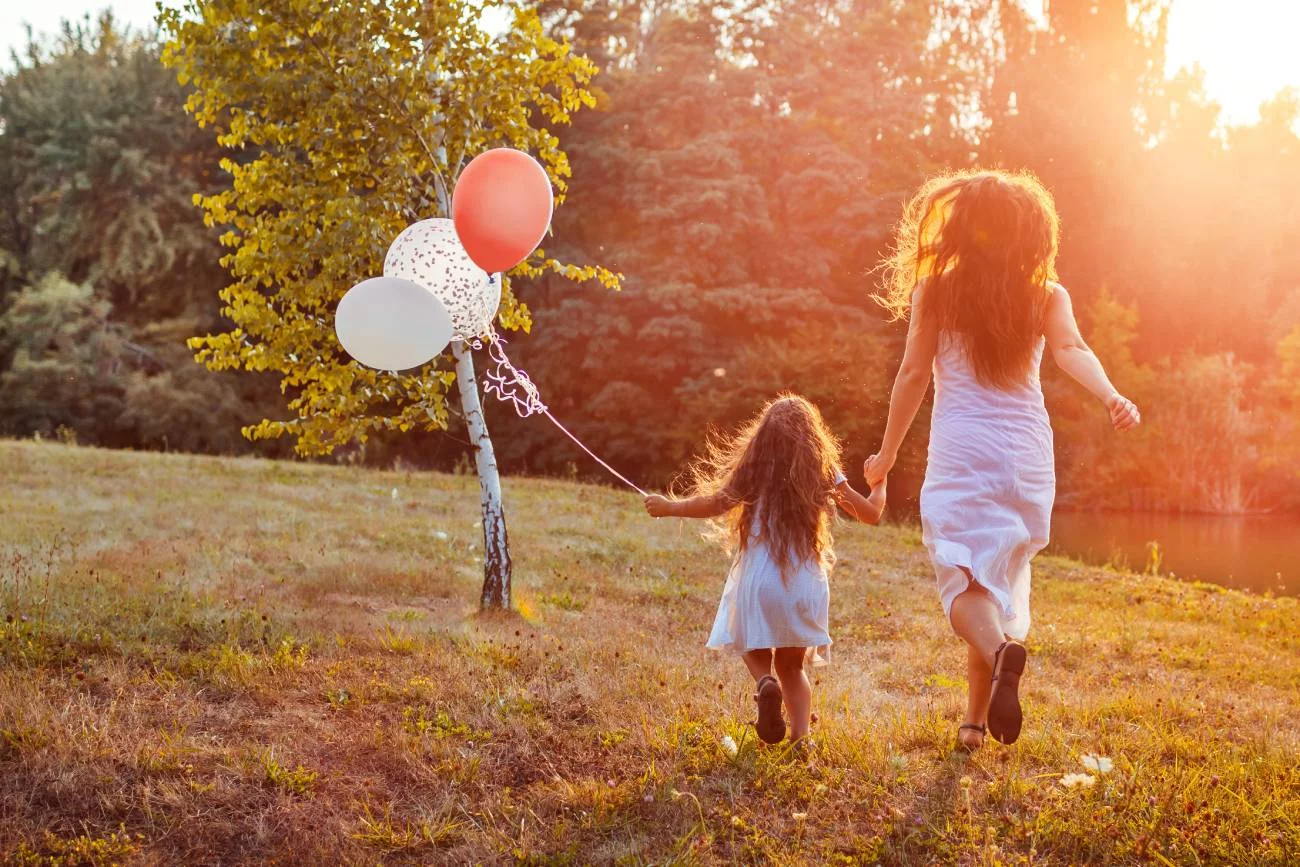 Mama bawi się z córką w zabawy na Dzień Dziecka na powietrzu.