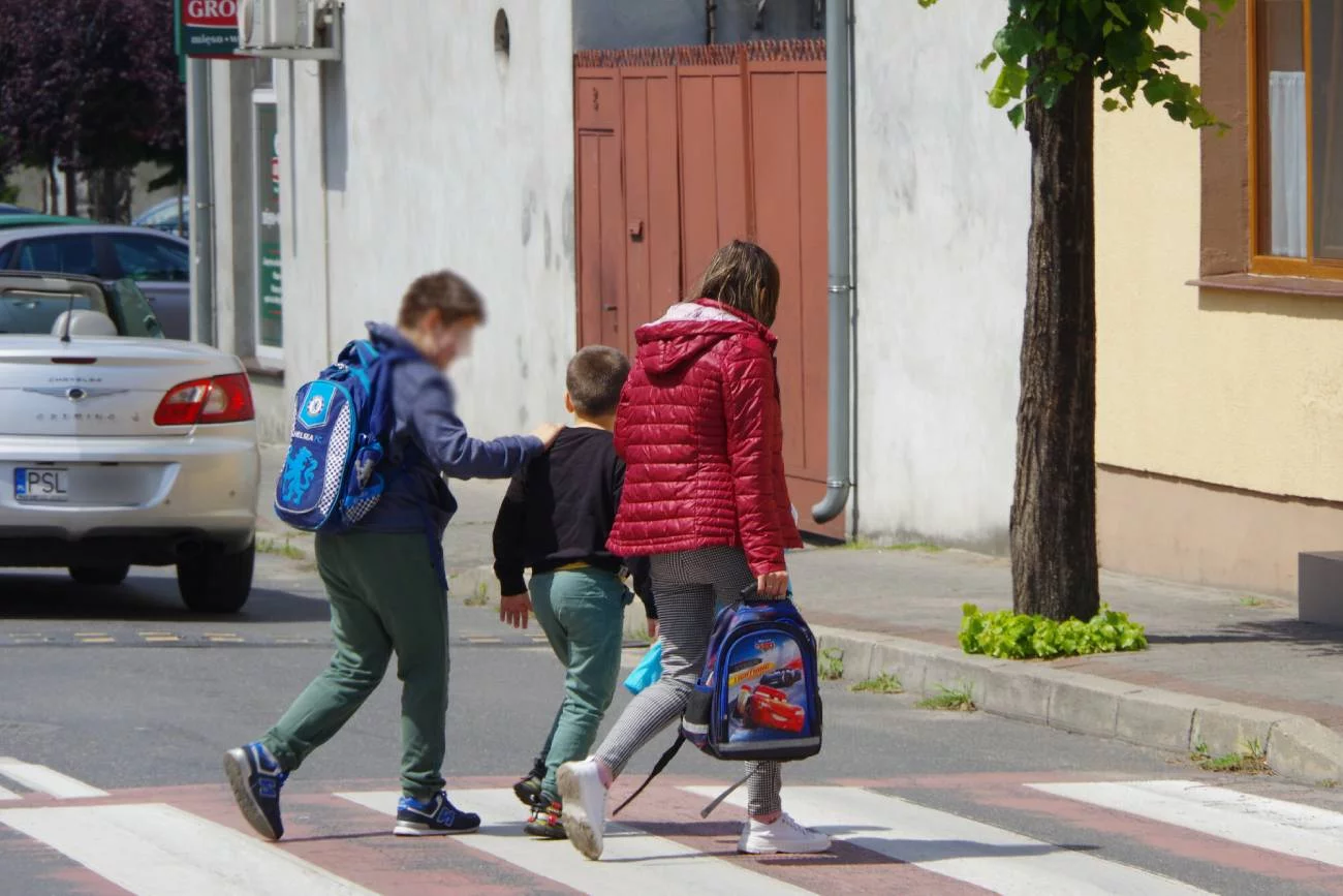 Kobieta wraca z dziećmi ze szkoły. Kobieta wraca z dziećmi ze szkoły.