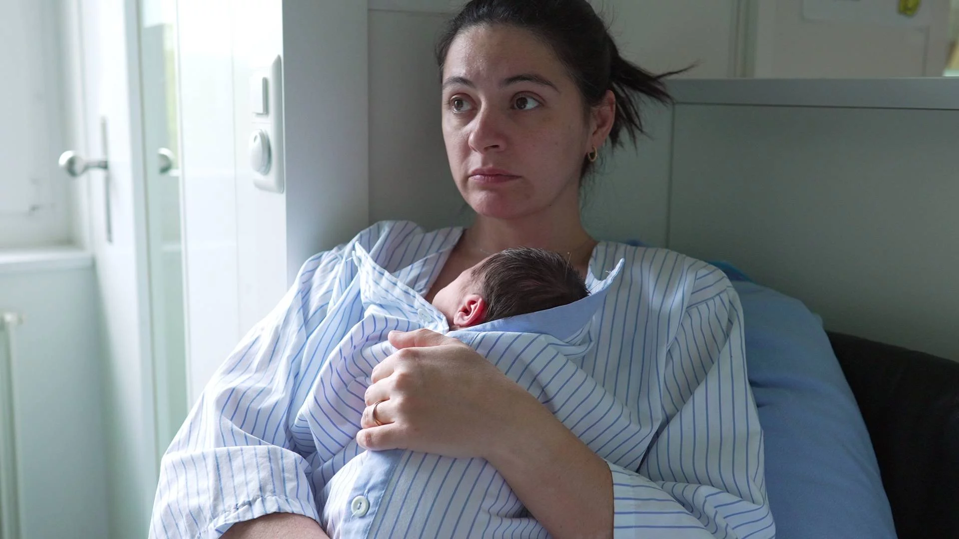 młoda mama z noworodkiem w szpitalu na oddziale położniczym