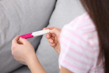 pierwszy miesiąc ciąży: kobieta z testem ciążowym