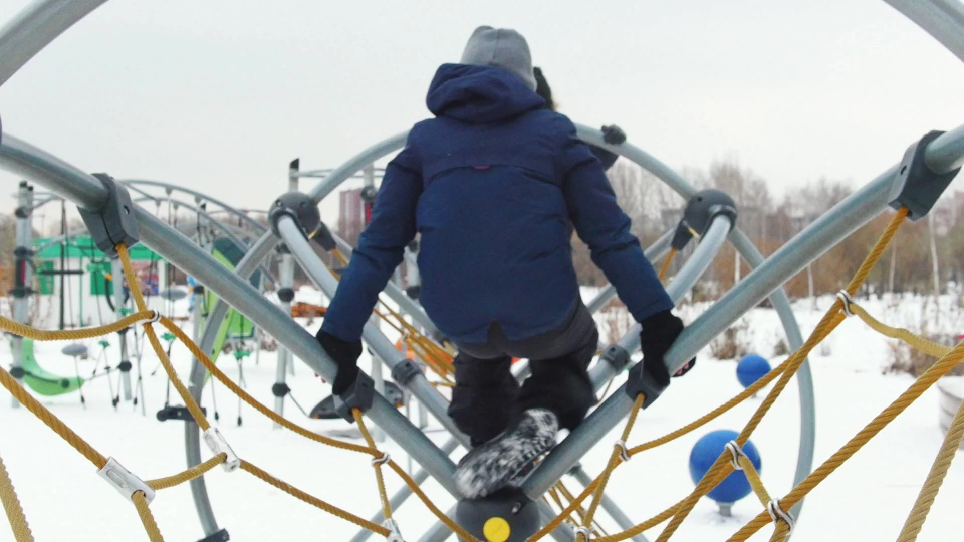 Dzieci bawią się zimą na placu zabaw