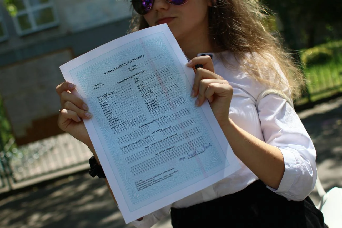 Uczennica ze świadectwem z czerwonym paskiem