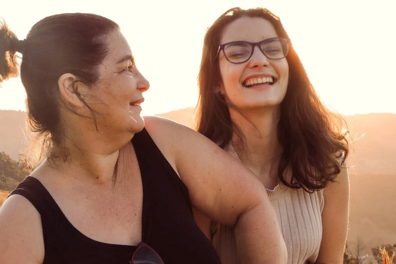 Mama i córka rozmawiają i śmieją się na spacerze.