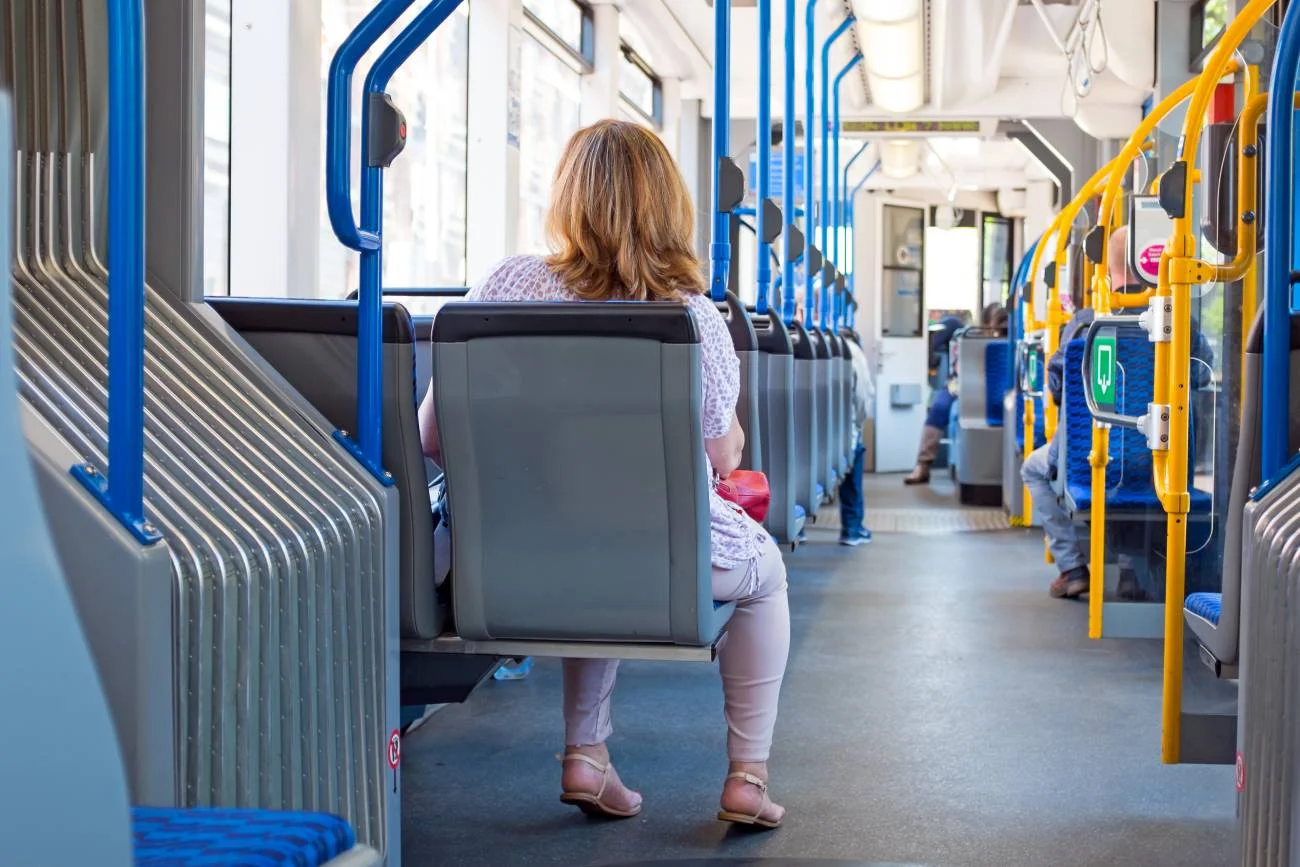 Kobieta jedzie autobusem miejskim.
