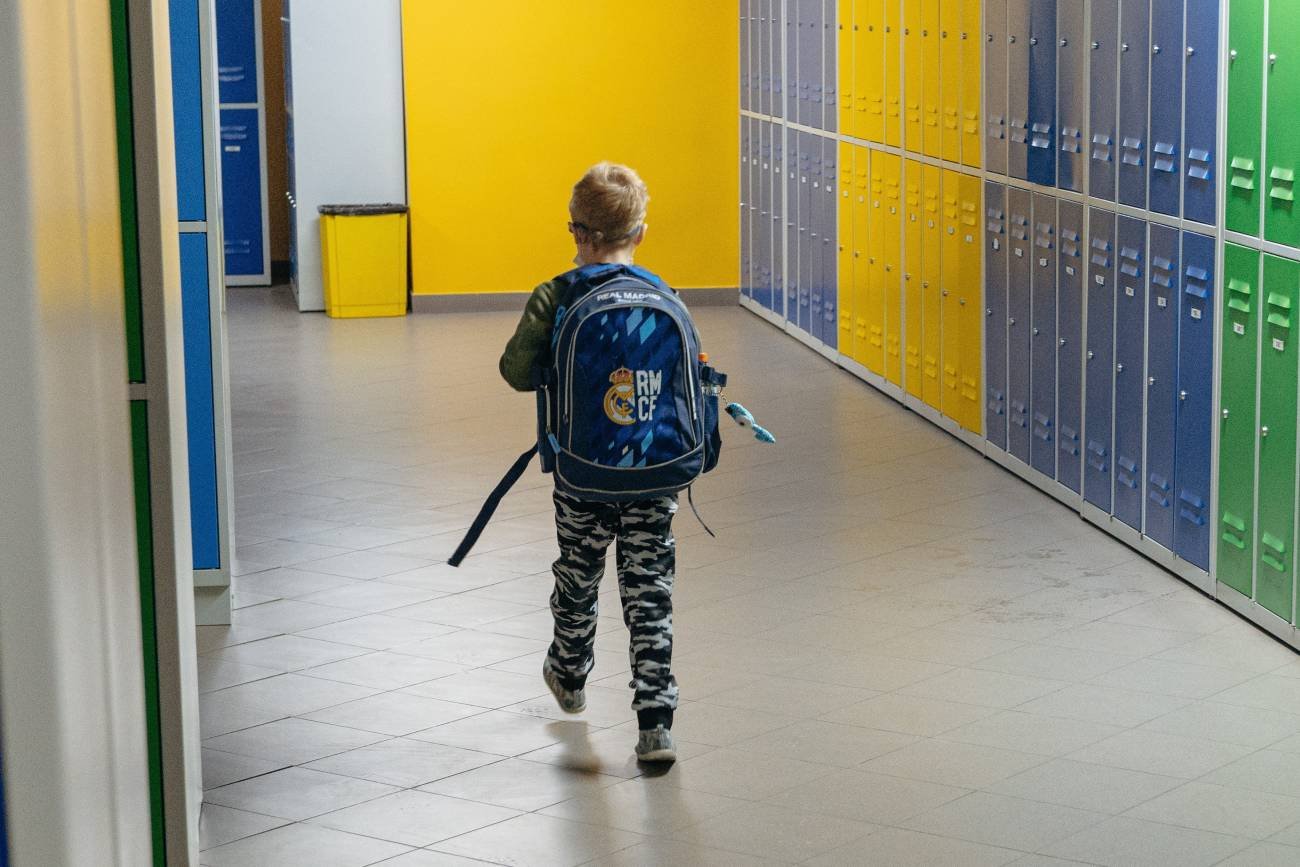 Chłopiec chodzi po szkolnym korytarzu, nie chce się uczyć po wystawieniu ocen
