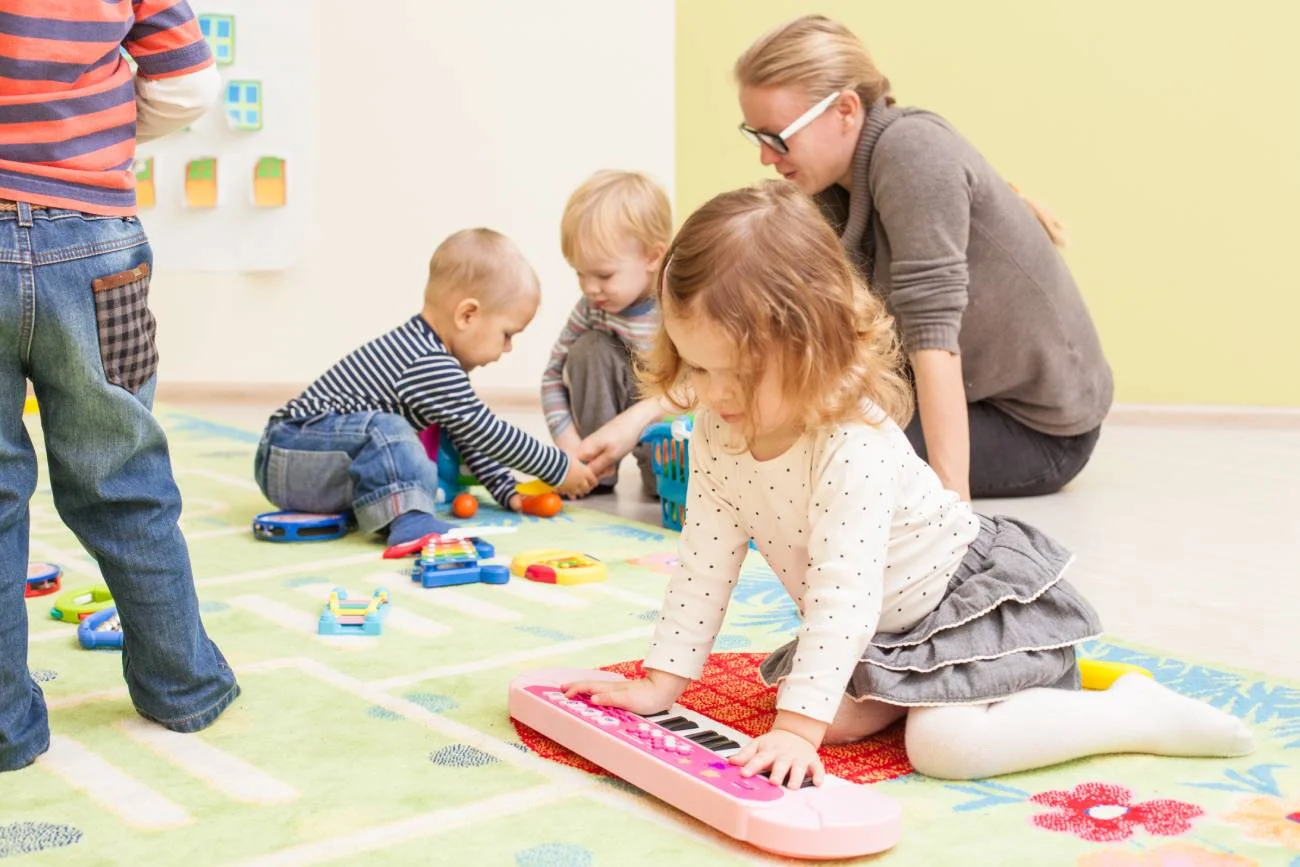 Dzieci bawią się w przedszkolu z nauczycielką.