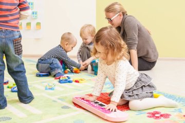 Dzieci bawią się w przedszkolu z nauczycielką.