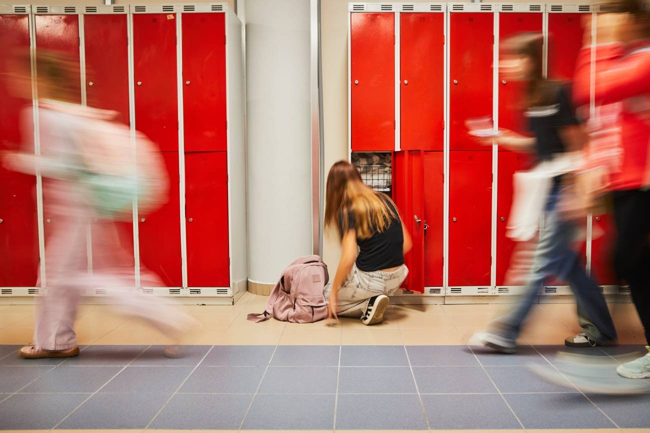 uczennica na szkolnym korytarzu chowa do szafki książki