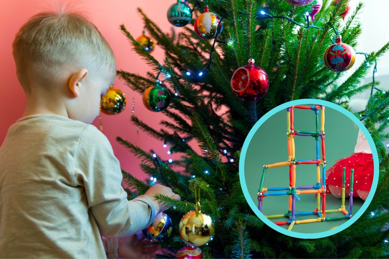 Kilkuletni chłopiec ubierający choinkę.