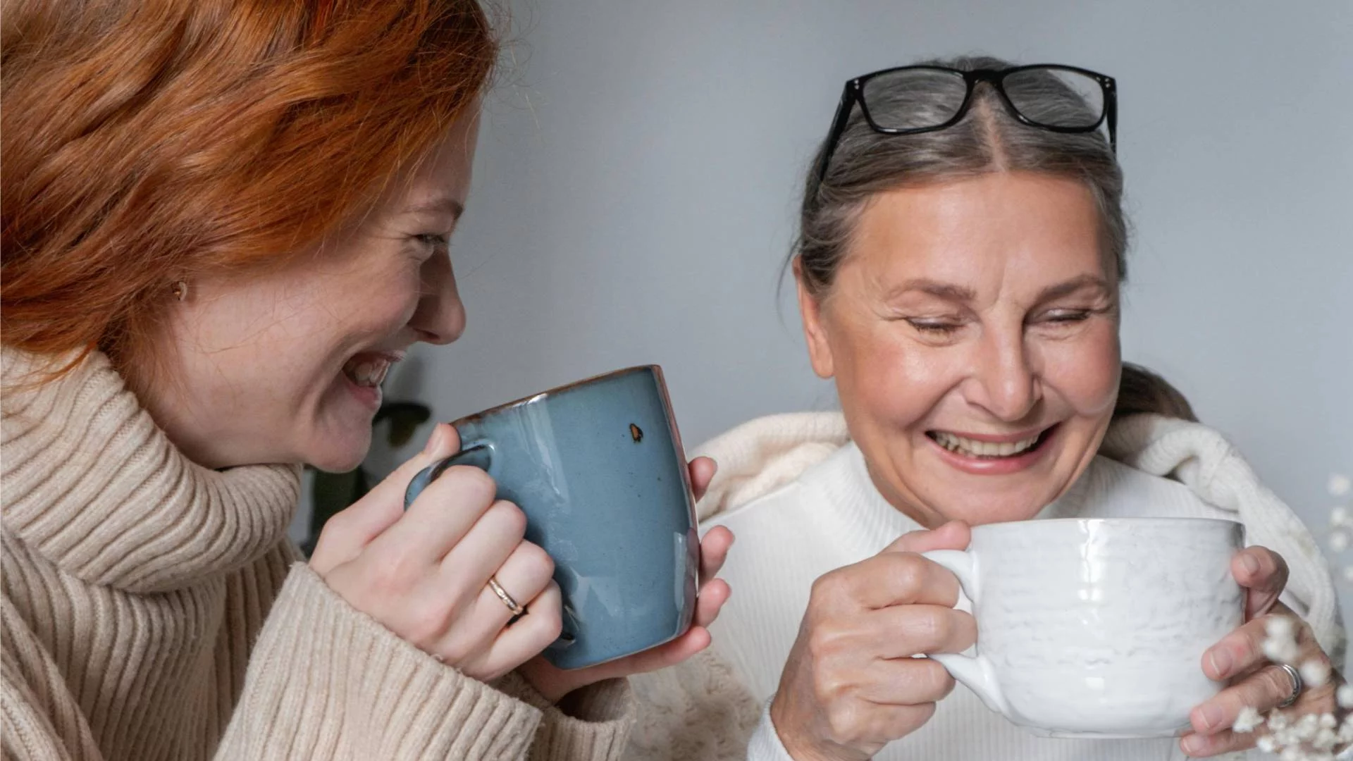 synowa z teściową śmieją się i razem piją herbatę