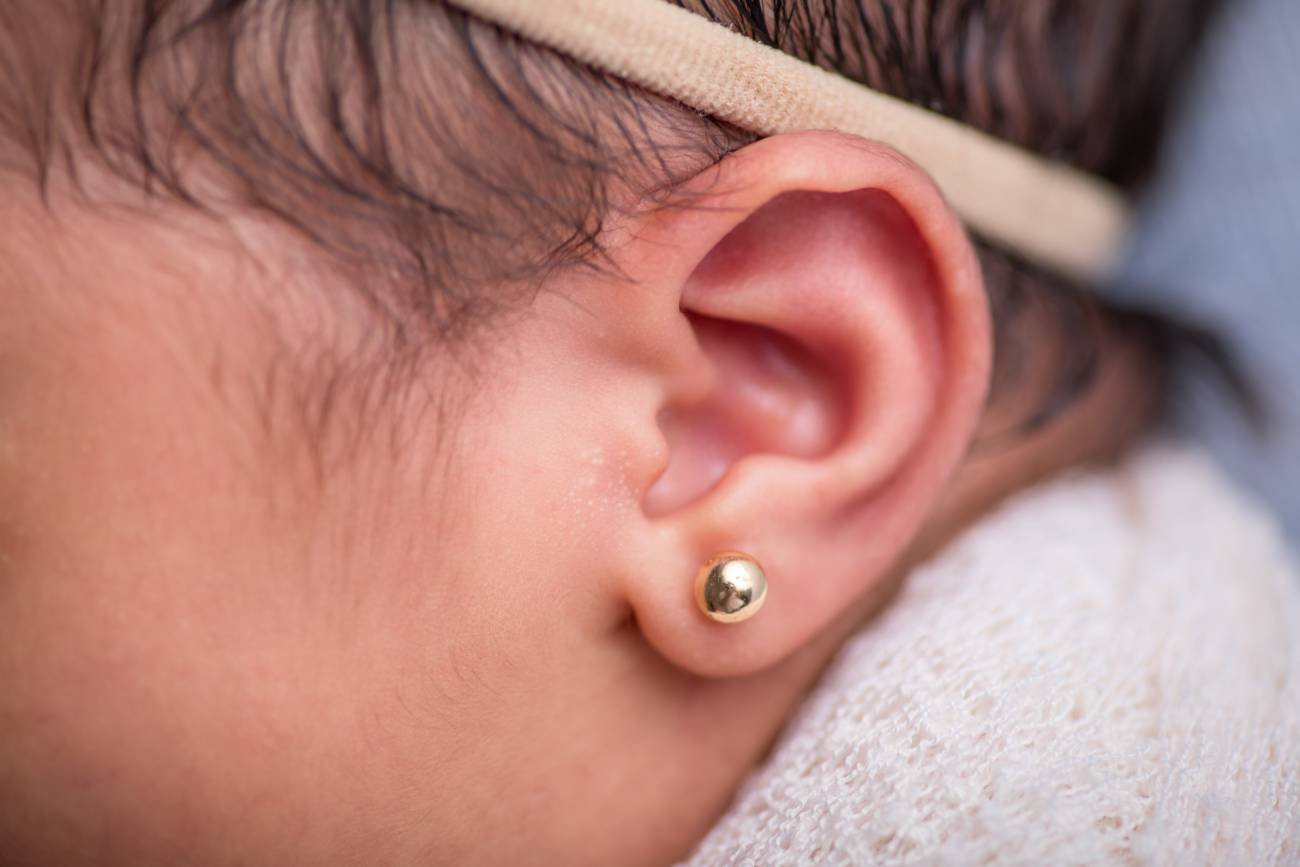Niemowlę z przekłutym uchem.