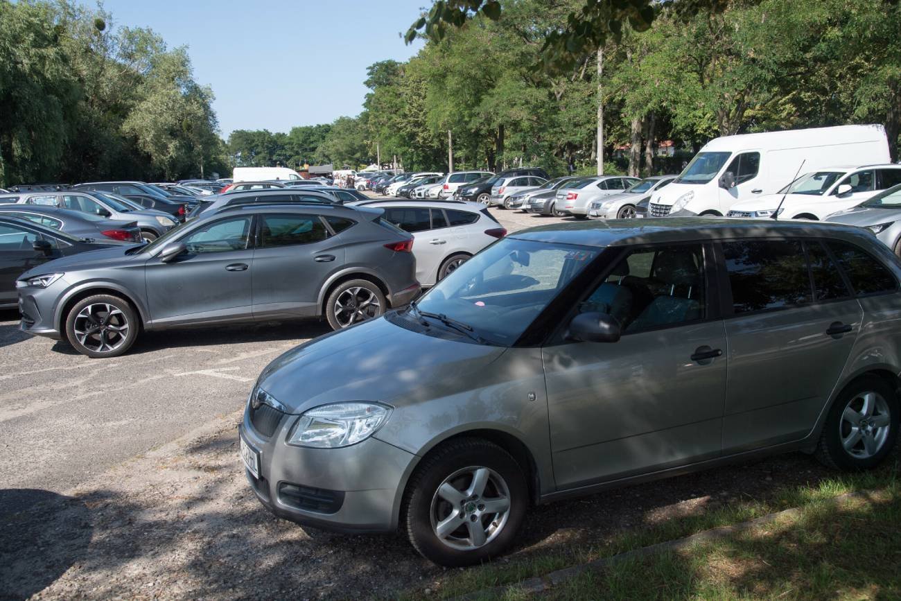 Samochody ustawione na rogrzanym parkingu.