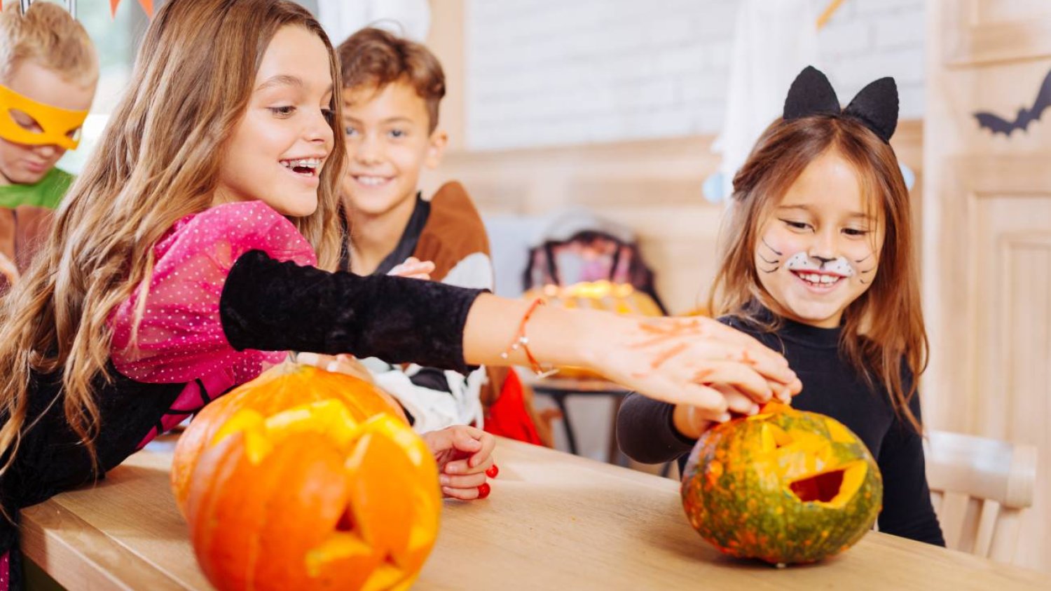 Uczniowie podczas lekcji wycinają dynię na Halloween.