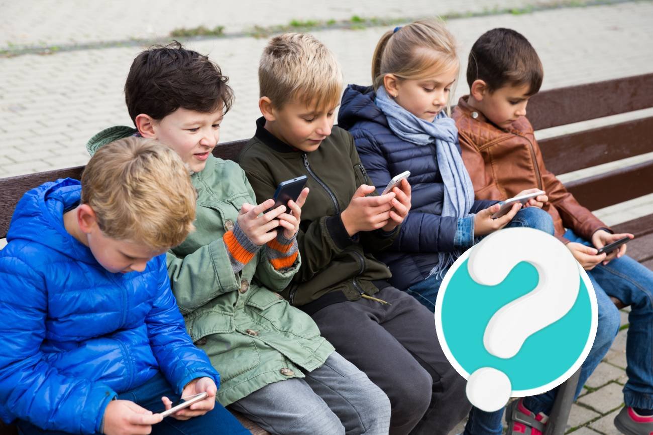 Dzieci z pokolenia alfa siedzą wpatrzone w smartfony.