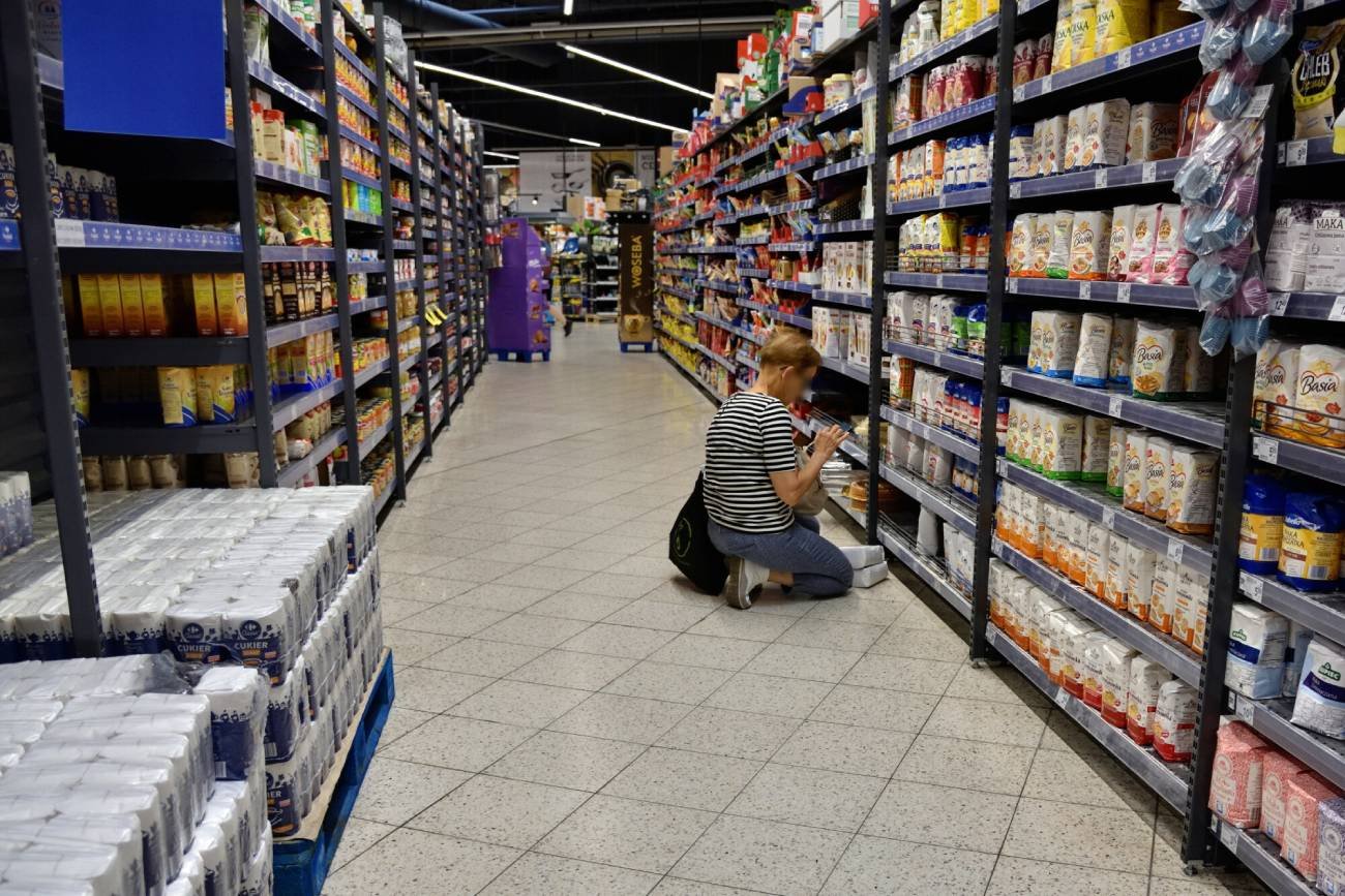 Kobieta w markecie czyta składy produktów.