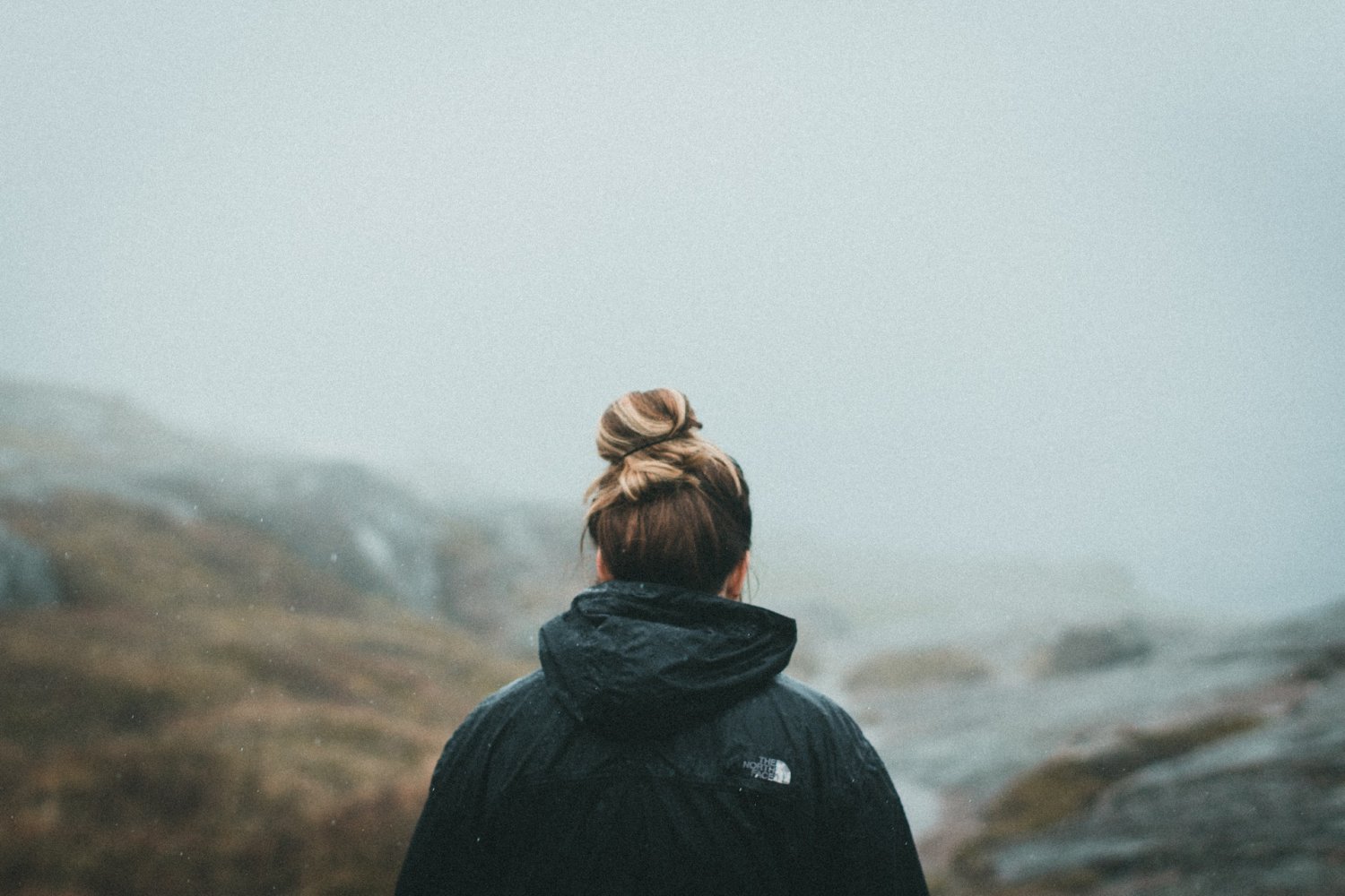 Kobieta stoi na tle gór.