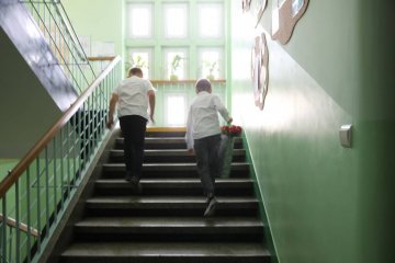 Uczniowie idą na zakończenie roku szkolnego.