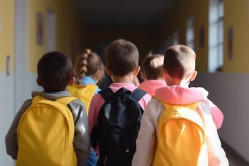Uczniowie idący szkolnym korytarzem do klasy na lekcję.