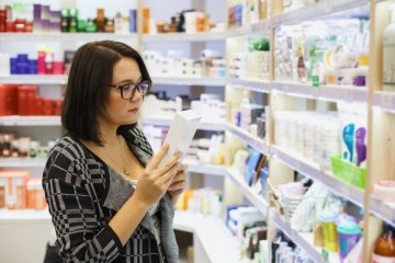 kobieta czyta etykietę na produkcie z apteki