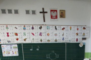 Klasa w szkole z krzyżem katolickim na ścianie.