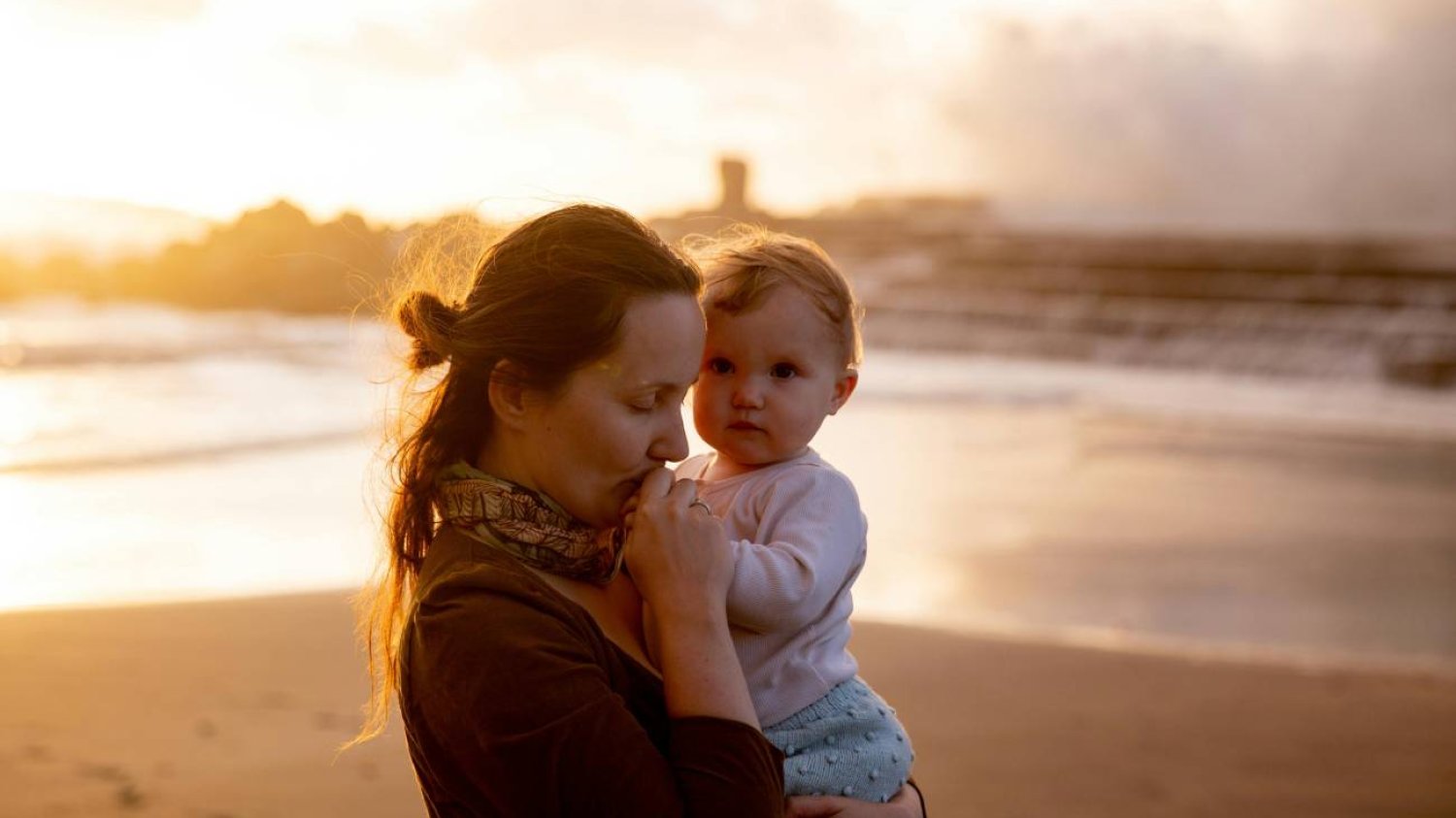 Mama z dzieckiem na spacerze na plaży Mama z dzieckiem na spacerze na plaży