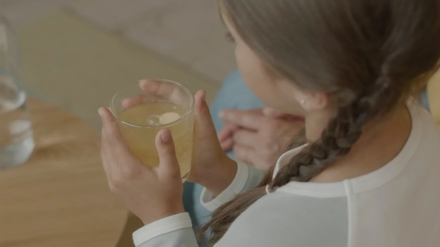 Naturalny sposób na odporność – napój, który naprawdę działa Na zdjęciu dziewczynka trzyma szklankę z napojem.