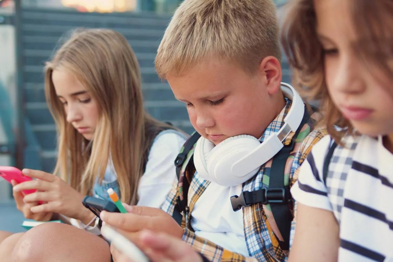uczniowie na przerwie patrzą w ekrany smartfonów