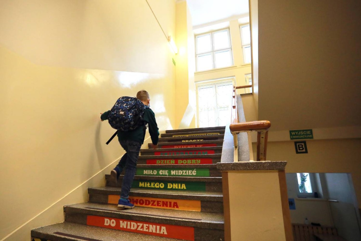 uczeń idzie po schodach w szkole