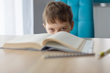 chłopiec siedzi w ławce szkolnej