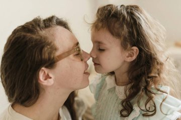 Mama i córka okazują sobie miłość, stykając się nosami.