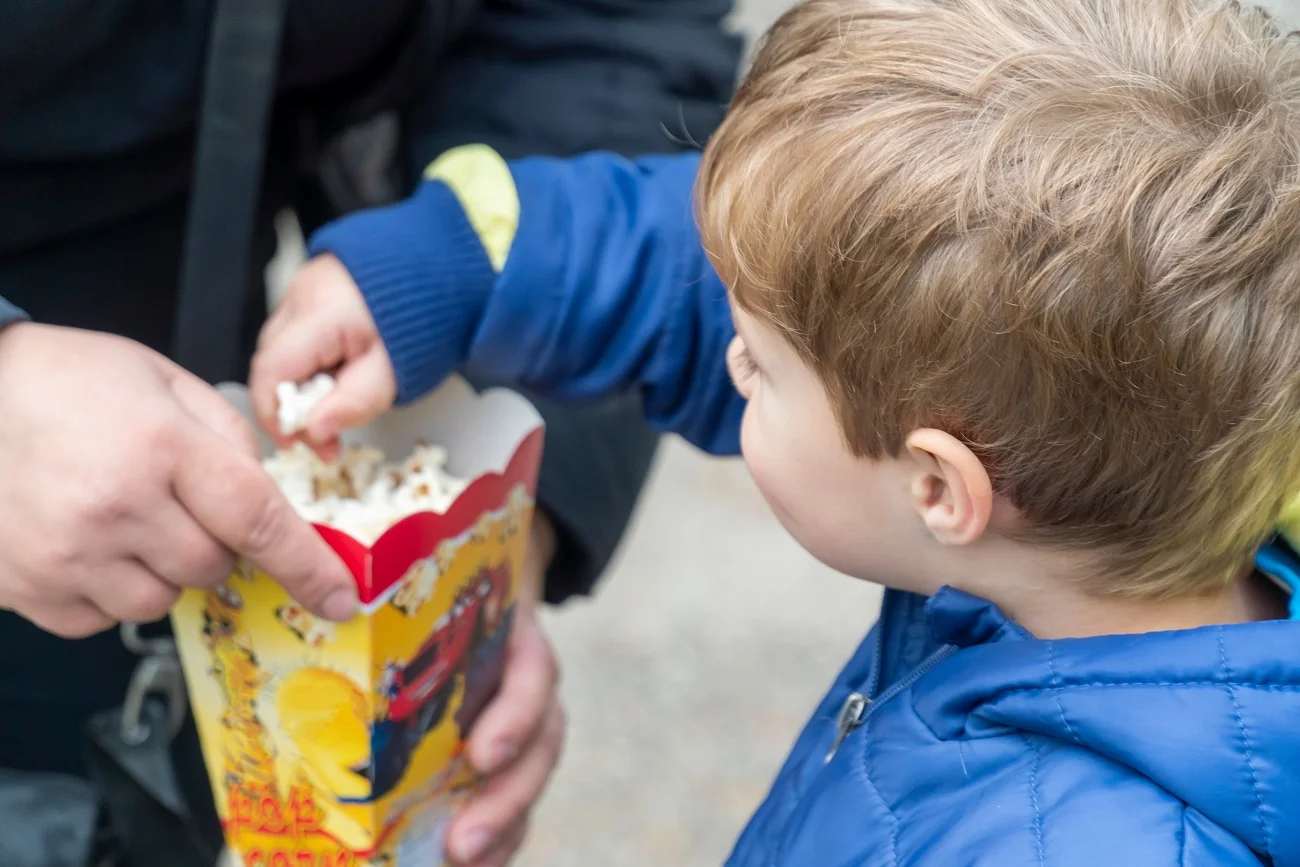 Chłopiec je popcorn.