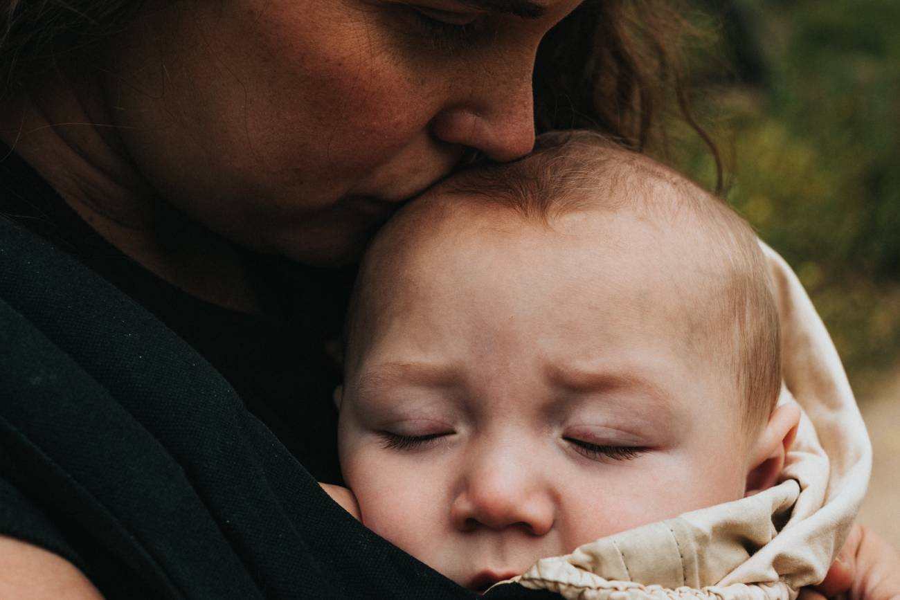 Matka całuje dziecko po głowie