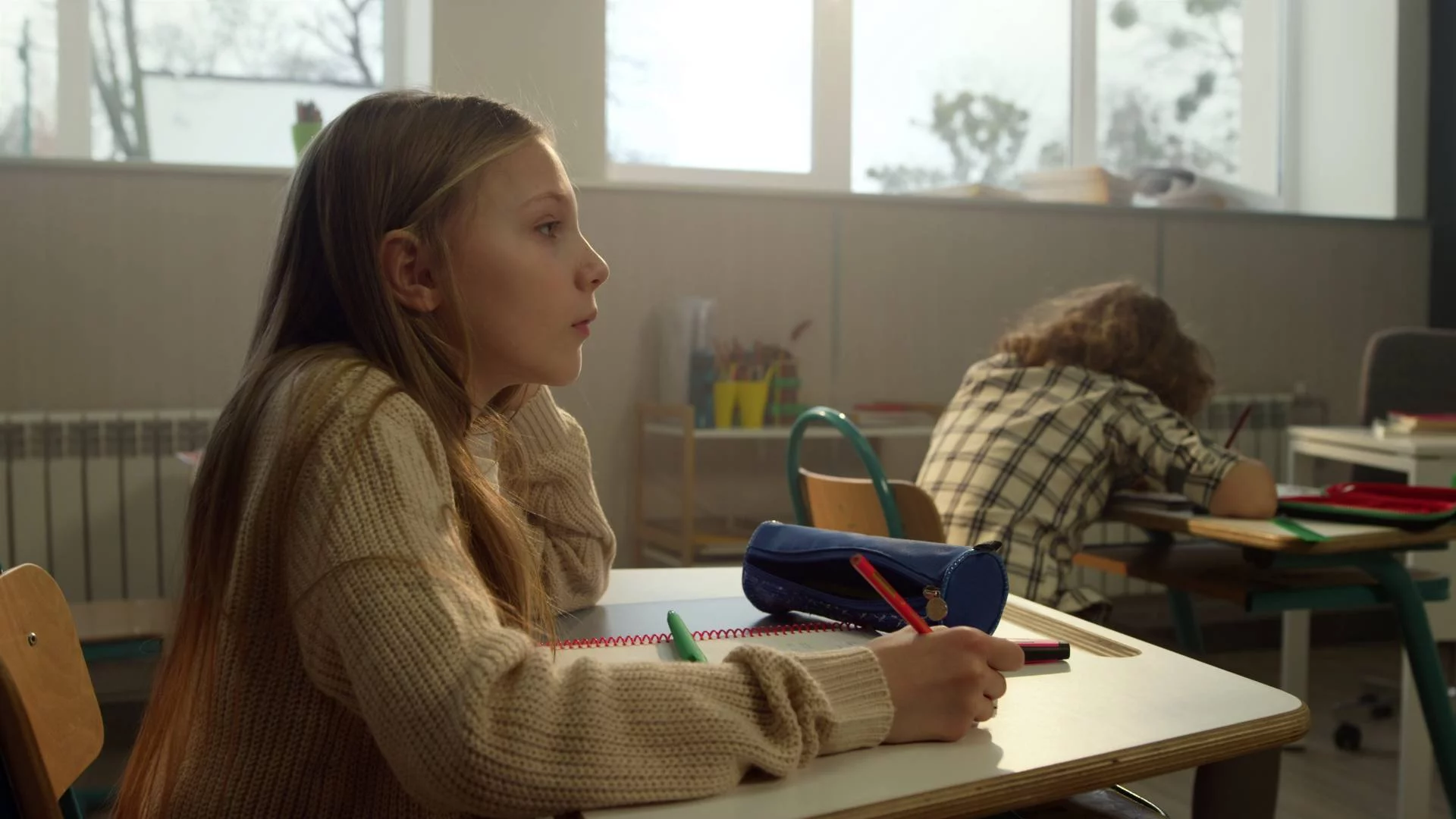 dziewczynka siedzi w ławce na lekcji w klasie