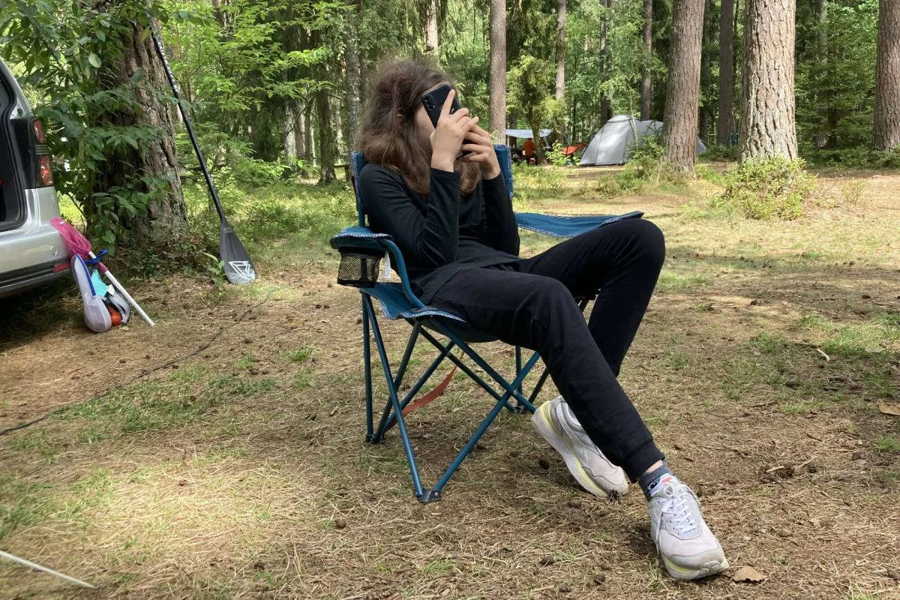 Samotna dziewczynka z telefonem w dłoniach.