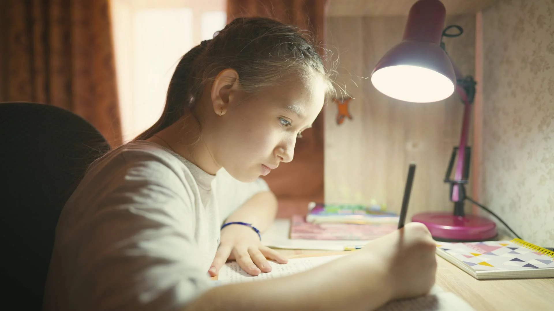 uczennica odrabia przy biurku pracę domową uczennica odrabia przy biurku pracę domową