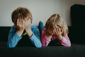 Dzieci, które nie czują się pewne siebie, zakrywają twarze ze wstydu lub smutku.